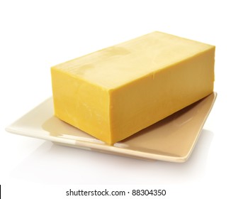 A Block Of Cheddar Cheese In A Dish