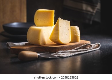 Block Of Hard Cheese. Sliced Cheese On Cutting Board.