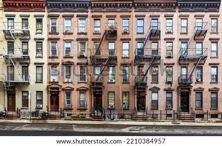 Block of historic apartment buildings crowded together on West 49th Street in the Hell's Kitchen neighborhood of New York City NYC