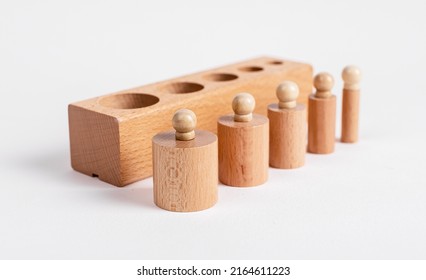 Block and Montessori knobbed cylinders placed in correct order from thicker to thinner. Wooden childish game for development of size perception and pincer grip. High quality photo