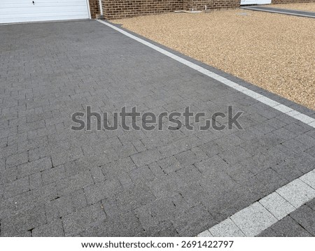 A block paved driveway bordered by a front garden laid to gravel - contrasting hard landscaping surfaces