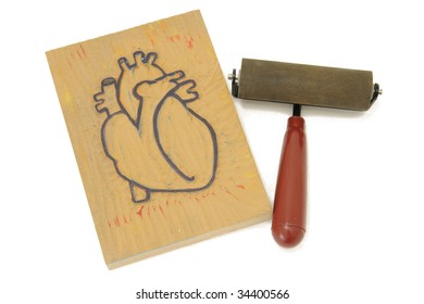 A Block Print Or A Heart Ready To Print With A Brayer That Will Be Used To Apply The Ink Before The Print Goes Through The Press.  Linoleum Block Carved By Photographer For Shoot.