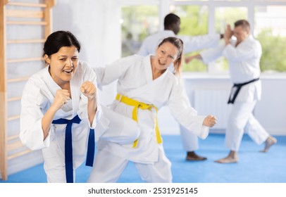 Block, then strike. Shot of two female martial artists practicing karate - Powered by Shutterstock