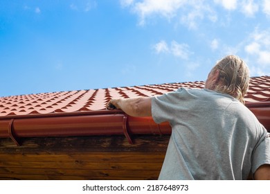 Blockage In The Drainpipe. A Man Removes Trash From A Roof Chute.