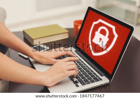 Blocked website or app and cyber security, ban or problems at work. Unrecognizable female hands typing on laptop enters login and password, at home or office with red screen and closed lock, close up