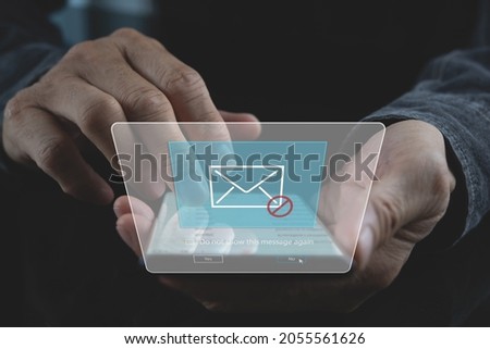Blocking spam e-mail, warning pop-up for phishing mail, network security concept. Business man using mobile phone checking email inbox with warning window on screen