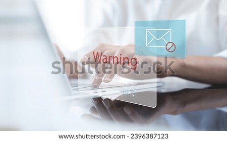 Blocking spam e-mail, warning pop-up for phishing mail, network security concept. Business woman working on laptop computer at home with warning window on screen, cyber security