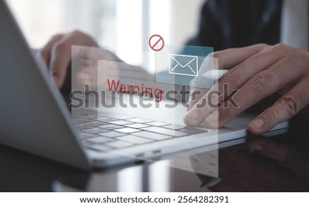 Blocking spam e-mail, warning pop-up for phishing mail, network security concept. Business man working on laptop computer at home with warning window on screen