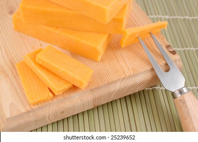 Blocks Of Cheddar Cheese On A Wooden Block With Cheese  Accessories