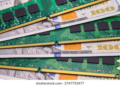 Blocks of computer memory sit on top of hundred dollar bills showing a mix of technology and money on a flat surface