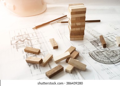 Blocks wood game (jenga) on blueprint or architectural project.