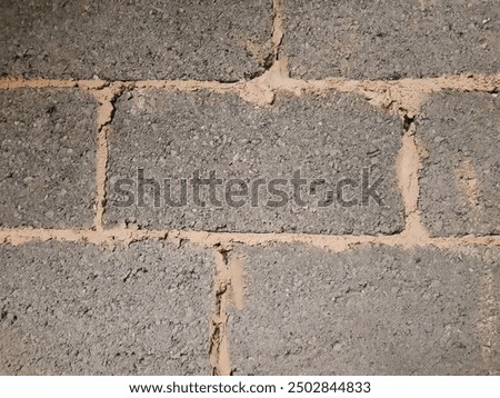A blockwork wall featuring untidy mortar joints