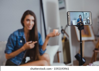 Blogger of caucasian woman with review product and talking camera live recording video on social network at home. Online merchants selling cosmetics on social media via mobile phones. - Shutterstock ID 1592193961