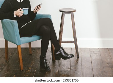 blogger girl checking her smartphone while drinking a coffee