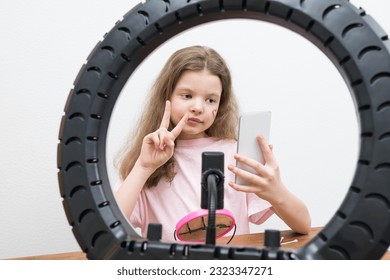 blogger girl makes a report showing signs with her hands in front of the phone - Shutterstock ID 2323347271
