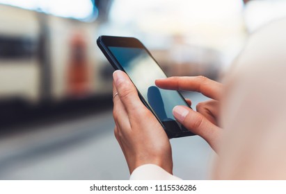 blogger hipster using in hands gadget mobile phone, woman texting message on blank screen smartphone, texting message, mockup online wifi internet concept, hipster waiting on station platform on back