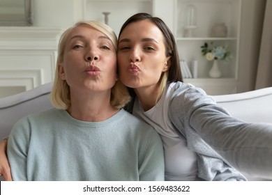 Blogger women use phone recording video vlog, faces of elderly mother and grown up daughter looking at camera blowing kisses make selfie webcam view, relative women family photography portrait concept