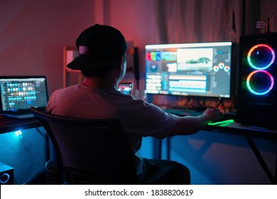 Blogger working editing video footage and looking at the monitor in-home office while working on post-production for a vlog. Selective focus person. - Shutterstock ID 1838820619