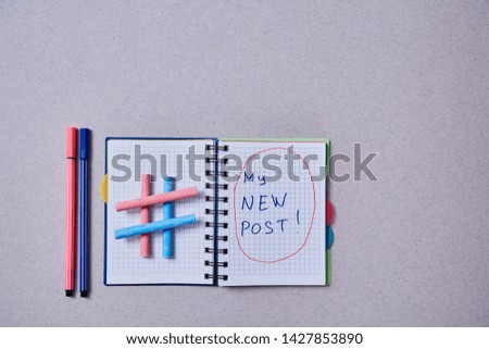 Blogging, blog and blogger or social media concept: notepad and hashtag symbol on grey background