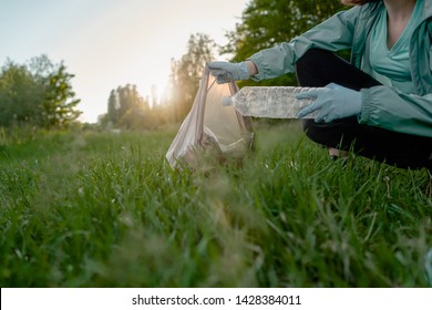 Blogging concept. The girl collects trash from the forest in the trash bag