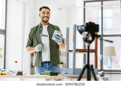 blogging, furniture restoration and home improvement concept - man or blogger with camera repainting old wooden table with paint roller in grey color and recording tutorial video