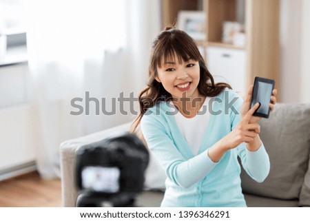 blogging, technology and videoblog concept - happy smiling asian woman or blogger with camera recording video blog of smartphone at home
