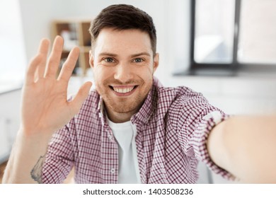 blogging, videoblog and people concept - man or blogger videoblogging or taking selfie and waving hand at home - Powered by Shutterstock