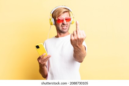 Blond Adult Man Feeling Angry, Annoyed, Rebellious And Aggressive With Headphones