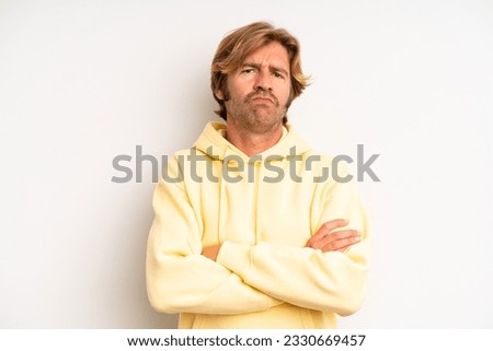 blond adult man feeling displeased and disappointed, looking serious, annoyed and angry with crossed arms