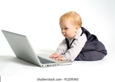blond baby in suit working with laptop