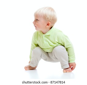 Blond Boy Barefooted Sitting At Floor And Looking Right Isolated On White