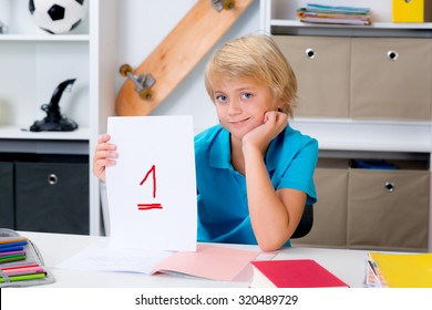 Blond Boy On Desk With Good Report Card