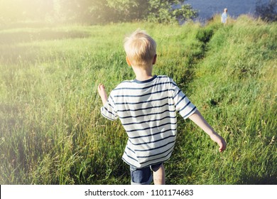 Blond Boy Running Into The Distance. A Child In Nature. Conceptual Realism.