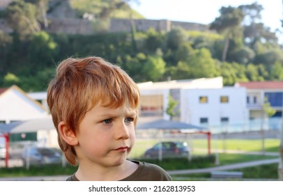 The Blond Boy Stares Into The Distance With A Perplexed Look. A Puzzled Five-year-old Boy. 