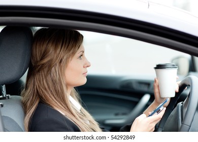 Blond Businesswoman Sending A Text While Driving To Work