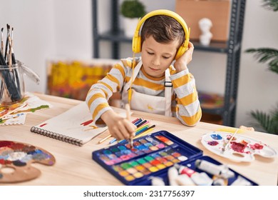 Blond child listening to music drawing at art studio - Powered by Shutterstock