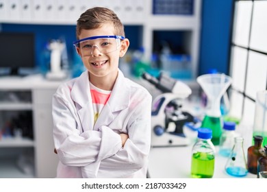 Blond Child Wearing Scientist Uniform Sitting With Arms Crossed Gesture At Laboratory