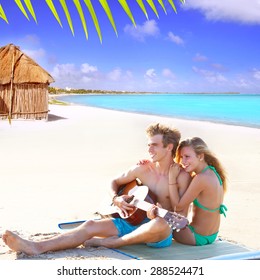 Blond Couple Sitting In The Cancun Beach Sand Playing Guitar Photo Mount