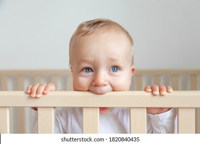 Blond Cute Little Baby Biting Wooden Bed Headboard