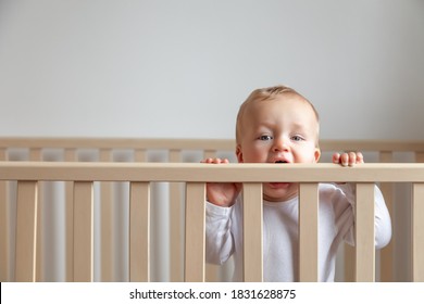 Blond Cute Little Baby Biting Wooden Bed Headboard