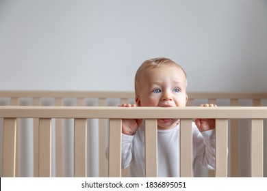 Blond Cute Little Baby Biting Wooden Bed Headboard