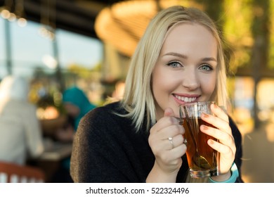blond drinking coffee or tea in caffe shop