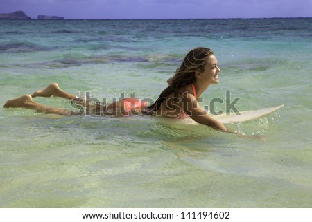blond girl in bikini with her surfboard