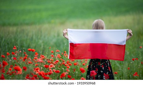 Blond girl holding flag of Poland in the poppy field. Back view. Polish Flag Day. Independence Day. Travel and learn polish language concept. Selective focus. - Shutterstock ID 1933950968