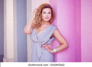 blond girl model plus size on the background of a pink wall