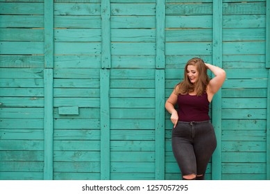 blond girl model plus size on the background of a green wall