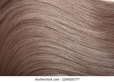 Blond hair close-up as a background. Women's long light brown hair. Beautifully styled wavy shiny curls. Hair coloring. Hairdressing procedures, extension. - Shutterstock ID 2245035777