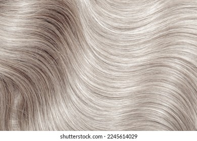 Blond hair close-up as a background. Women's long blonde hair. Beautifully styled wavy shiny curls. Hair coloring. Hairdressing procedures, extension. White hair - Shutterstock ID 2245614029