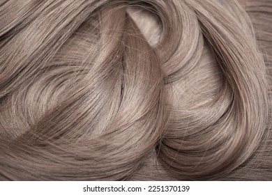 Blond hair close-up as a background. Women's long light brown hair. Beautifully styled wavy shiny curls. Hair coloring. Hairdressing procedures, extension. - Shutterstock ID 2251370139