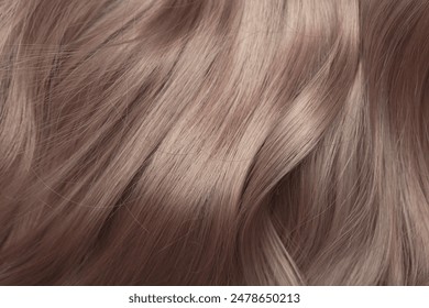 Blond hair close-up as a background. Women's long light brown hair. Beautifully styled wavy shiny curls. Hair coloring. Hairdressing procedures, extension. - Powered by Shutterstock